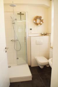 y baño blanco con ducha y aseo. en Urlaubsfreude Biedermann Haus Blumenglück - Hortensie en Sebnitz