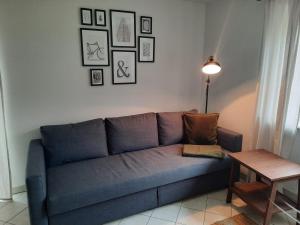 a blue couch in a living room with a table at Ferienwohnung No 15 in Pfullendorf