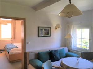 a living room with a blue couch and a bed at Hotel-Pension Seeadler in Prerow