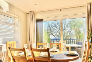 une salle à manger avec une table, des chaises et une grande fenêtre dans l'établissement 16 Beatrice Avenue, à Shanklin