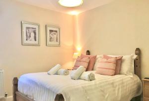 - une chambre avec un grand lit blanc et des oreillers dans l'établissement 16 Beatrice Avenue, à Shanklin