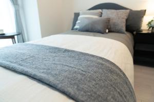 Una cama con una manta azul encima. en OSAKA SUNSHINE TOWER81, en Osaka 16 fotos más