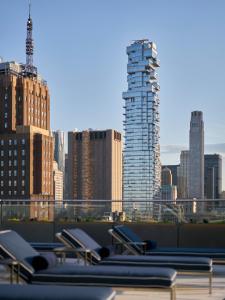 a row of chairs on a roof with a city skyline at ModernHaus SoHo in New York