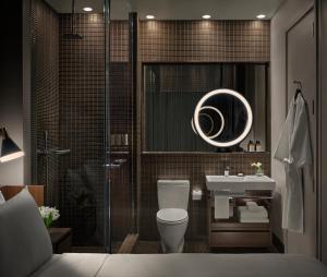 a bathroom with a toilet and a sink and a mirror at ModernHaus SoHo in New York