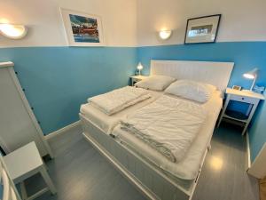 1 dormitorio con 1 cama grande y pared azul en Nord Nord West, en Wyk auf Föhr