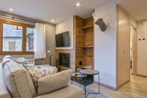 a living room with a couch and a tv at Luderna - Apartamento Des Puis in Gessa