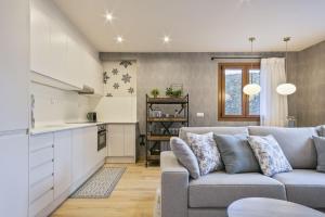 a living room with a couch and a kitchen at Luderna - Apartamento Des Puis in Gessa