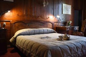 um quarto com uma cama grande e uma cabeceira em madeira em Château de Passières em Chichilianne