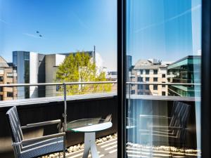 a balcony with a table and chairs and a window at Plaza Hotel & Living Frankfurt in Frankfurt/Main +40 photos