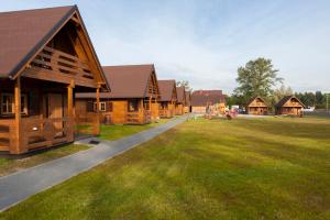 eine Reihe von Holzhäusern auf einem Grasfeld in der Unterkunft Agroturystyka nad Morzem in Ustka