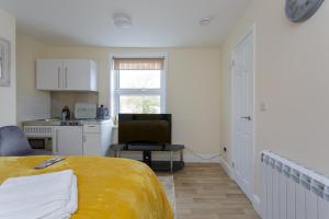 a white room with a bed and a kitchen at St Mary's - Modern Central Huge Studio Apartments in Southampton