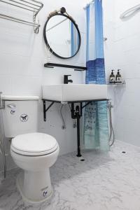 a bathroom with a toilet and a sink and a mirror at 島氮潛水背包客棧 PlayfulDiveClub in Xiaoliuqiu