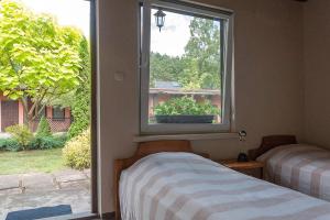 a bedroom with a window looking out at a yard at Ośrodek Edward in Mikoszewo