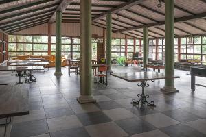 a large room with tables and chairs and windows at Ośrodek Edward in Mikoszewo