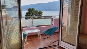 a room with a balcony with a view of the ocean at Sunrise Apartment in Baošići
