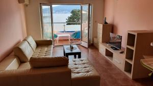 a living room with a couch and a view of the ocean at Sunrise Apartment in Baošići