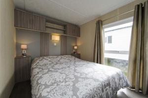 een slaapkamer met een groot bed en een raam bij Bungalette Sauna 4p in Zuna