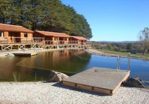 a house with a dock in the middle of a river at Parque Biologico de Vinhais in Vinhais