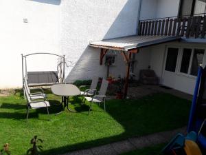 a patio with a table and chairs on the grass at Ferienwohnung Schwarzbauer in Illmitz