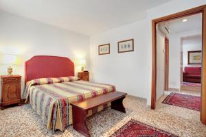 una camera con letto, tavolo e specchio di Palazzo Schiavoni Residenza d'Epoca & Suite-Apartments a Venezia