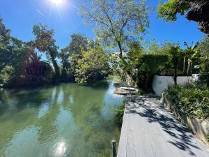 a river with a wooden walkway and trees on the side at Villa Louise-Rose in Villeneuve-Loubet