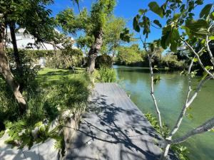 une passerelle en bois à côté d'une rivière arborée dans l'établissement Villa Louise-Rose, à Villeneuve-Loubet