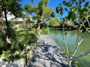 a wooden walkway next to a river with trees at Villa Louise-Rose in Villeneuve-Loubet