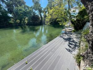 une passerelle en bois à côté d'une rivière arborée dans l'établissement Villa Louise-Rose, à Villeneuve-Loubet