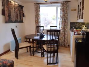 a dining room with a table and chairs and a window at Song of the Sea, Selkie House in Helmsdale