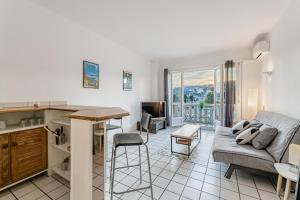 une cuisine et un salon avec un canapé et une table dans l'établissement Les pieds dans l'eau par Dodo-a-Cassis, à Cassis