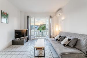 un salon avec un canapé et une télévision dans l'établissement Les pieds dans l'eau par Dodo-a-Cassis, à Cassis