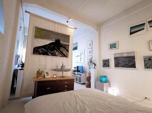 a bedroom with a bed and a painting on the wall at Studio Blank - a night in the gallery in Den Oever