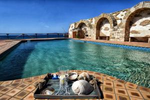 Luxurious Villa by the sea في Posidhonía: حمام سباحة مع طاولة مع صينية طعام