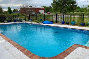 una gran piscina azul frente a una valla en Pet-Friendly Home 7 Miles to Dickson Street!, en Fayetteville