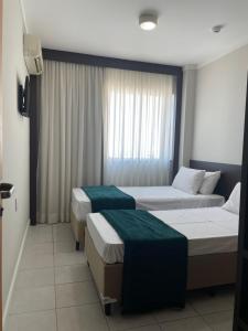 ein Hotelzimmer mit 2 Betten und einem Fenster in der Unterkunft Flat TRIANGULO DAS BERMUDAS Home Experience Praia do Canto in Vitória