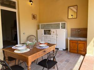 トッレ・デル・ラーゴ・プッチーニにあるLa casa di Albyのキッチン(木製テーブル、皿、ワイングラス付)