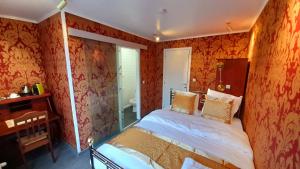 a bedroom with orange walls and a bed in it at Bosdam Budget Rooms in Beveren