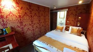 una camera da letto con un letto con carta da parati rossa di Bosdam Budget Rooms a Beveren