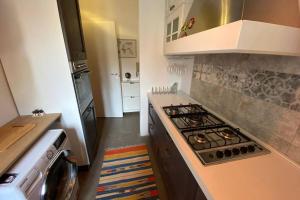 リヴォルノにあるFashion House in Livorno centroのコンロ付きのキッチン 洗濯機の横にあるトップオーブン +15枚の写真