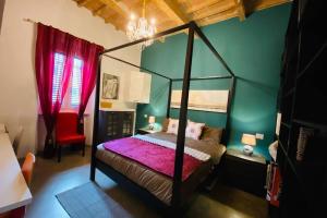 リヴォルノにあるFashion House in Livorno centroのベッドルーム1室(ピンクのシーツが備わる四柱式ベッド1台付)