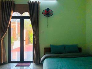 a bedroom with a bed and a large window at Vy Ly Motel in Phú Quí (2)