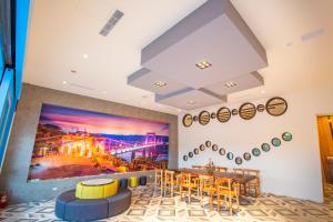uma sala de jantar com uma grande pintura na parede em San Chiao Hotel em Daxi
