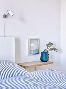 a bedroom with a bed and a blue vase with a plant at See 11 in Harrislee