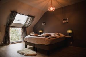 - une chambre avec un grand lit et une fenêtre dans l'établissement LOGIS-Hôtel La Gentilhommière, à Artres