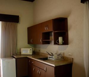 a kitchen with a stove top oven and a microwave at Hotel Villa Therese in Port-au-Prince