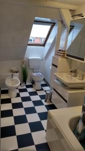 uma casa de banho com piso em xadrez preto e branco em Eulen- & Altstadtnest em Peine
