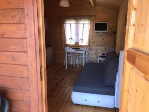 una habitación con sofá y mesa en una cabaña en Cattleya 2, en Wicko