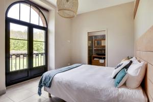 a bedroom with a bed and a large window at Grand Jardin - Clairefontaine in La Hunière