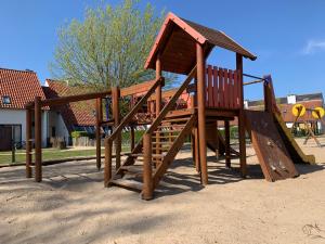 a wooden playground with a slide in a park at Ysermonde Fisherman's Cottage in Nieuwpoort