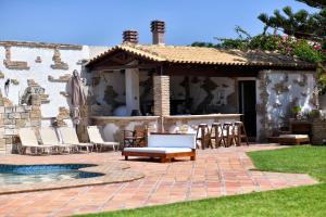 eine Terrasse mit Stühlen und einem Pool vor einem Haus in der Unterkunft Luxurious Villa by the sea in Posidhonía